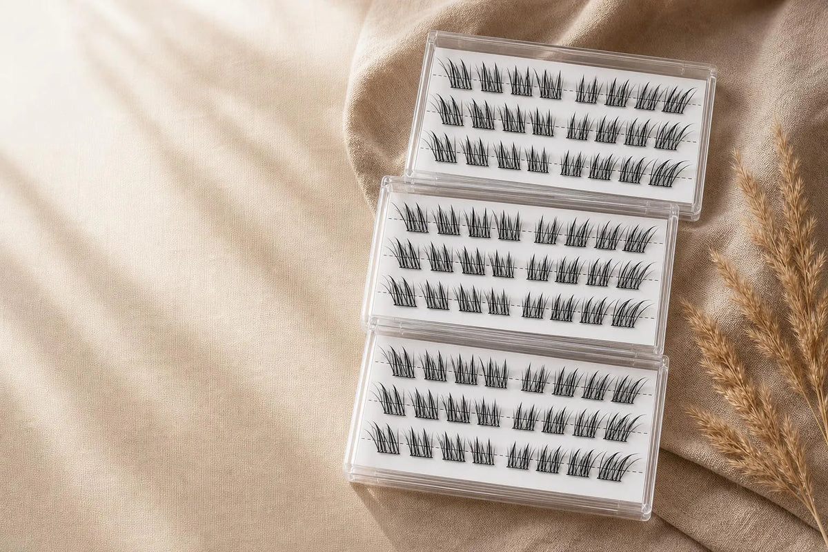 Three cases of Buviro lash clusters stacked on linen