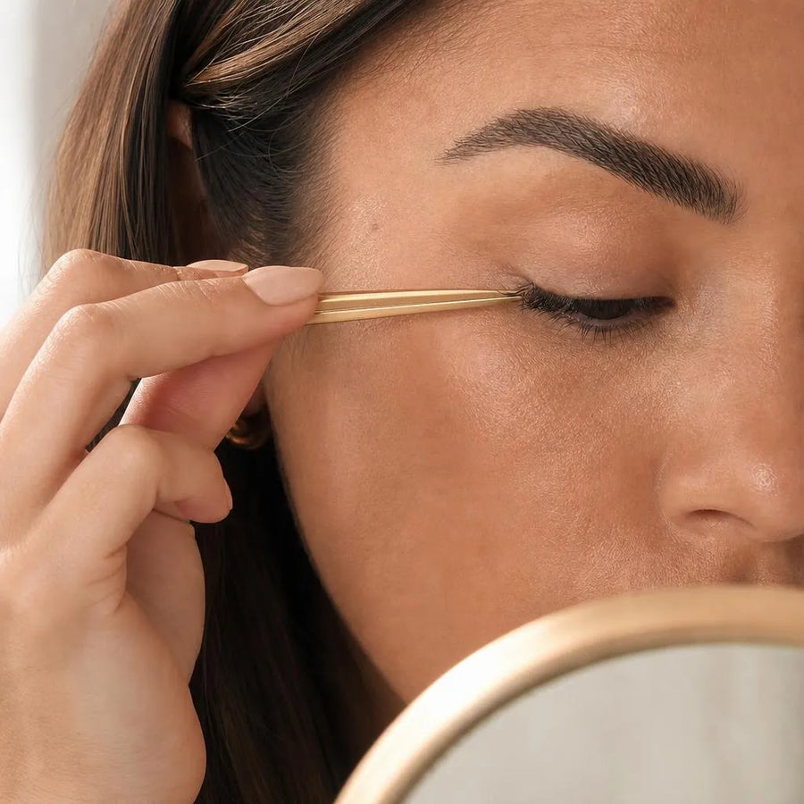 Gently pinching the lash cluster and natural lashes together to set it